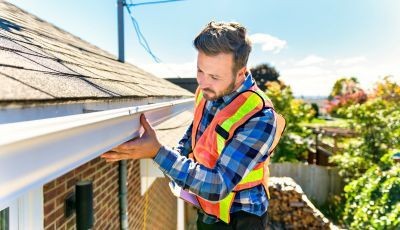 Roofing professional in Tampa inspecting a residential roof. 